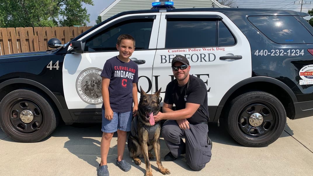 Брейди Снаковский вместе с полицейским и собакой, которому приобрели бронежилет