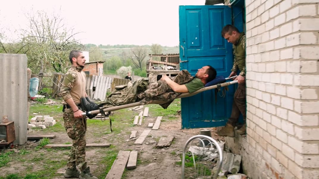 Медики 10-й горно-штурмовой бригады несут раненого бойца