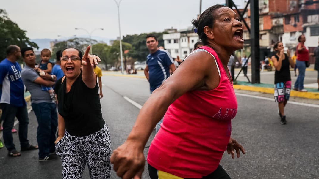 Женщины кричат на улице в Каракасе из-за того, что в их домах нет ни воды, ни света, Венесуэла, 31 марта 2019 года