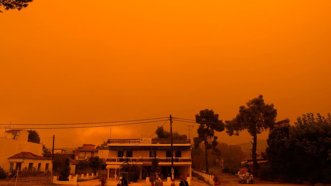 Люди идут на эвакуацию из поселка Пефки на острове Эвия в Греции, 8 августа 2021 года