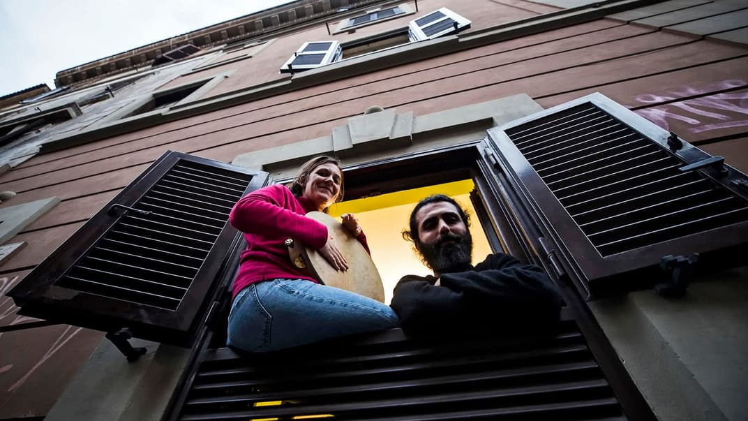 Під час панічних атак психологи радять також співати, це гарно допомагає відволіктися. На фото — італійська пара під час карантину через коронавірус грає і співає, сидячі на підвіконні своєї квартири у Римі, Італія, 14 березня 2020 року