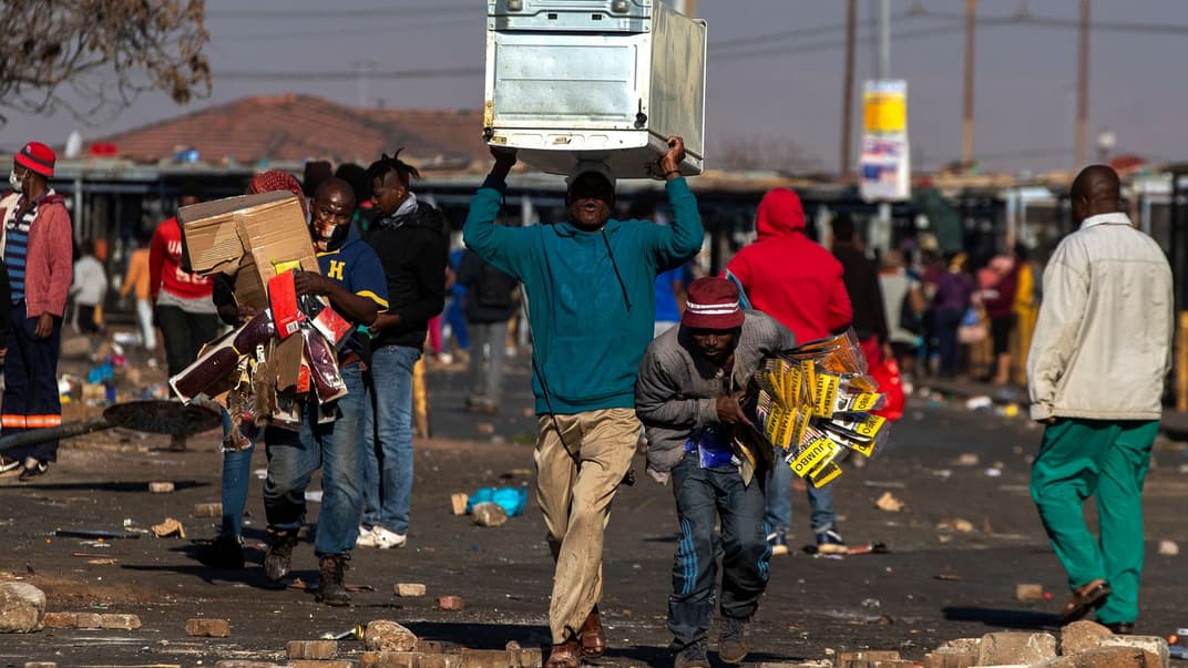 Мародери переносять речі з торгового центру Letsoho у місті на схід від Йоганнесбурга, ПАР, 12 липня 2021 року