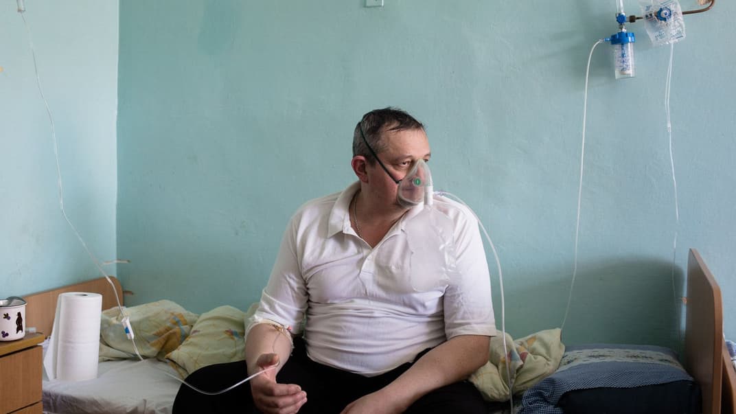 Мужчина с коронавирусной болезнью смотрит в окно в палате больницы в г. Яремче