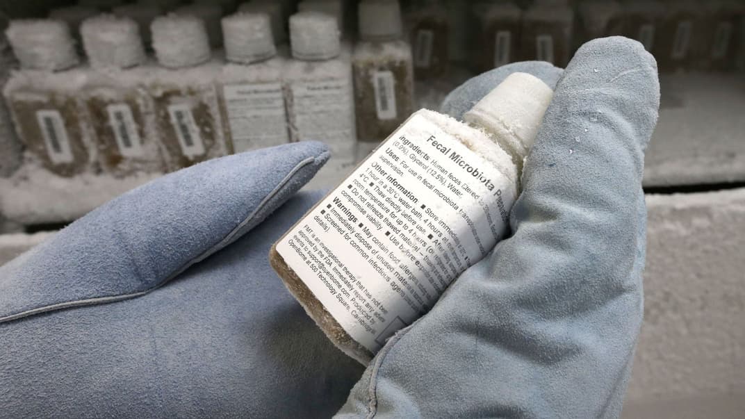 Технічна працівниця Еліска Дідик у захисних рукавичках демонструє пляшку з розчином людських фекалій, заморожену до мінус 80 градусів за Цельсієм, у лабораторії OpenBiome, у Медфорді, штат Массачусетс, 19 червня 2014 року.