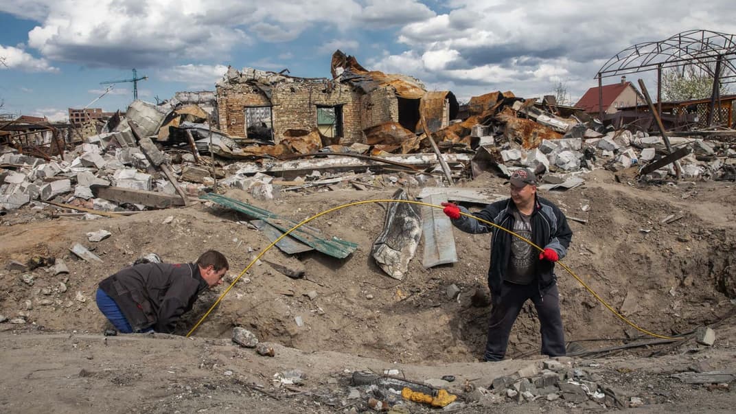 Чоловіки проводять підземний кабель для організації інтернет-звʼязку в Бучі