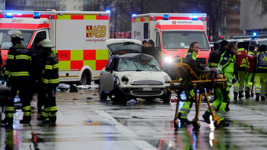 Поліція та екстрені служби стоять біля пошкодженого автомобіля, який, імовірно, в’їхав у демонстрантів у Мюнхені, 13 лютого 2025 року
