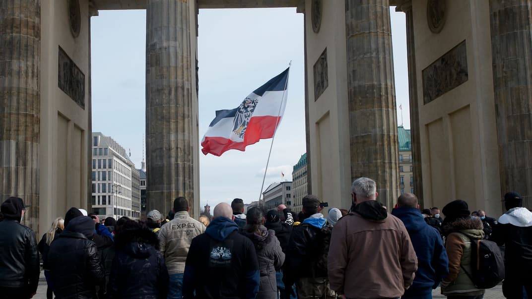 Прапор у кольорах Німецької імперії та з прусським геральдичним орлом під час демонстрації правих екстремістів і «громадян Рейху» біля Бранденбурзьких воріт у Берліні, 20 березня 2021 року