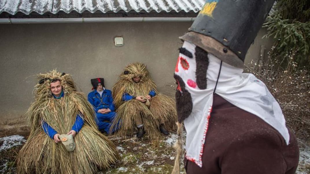 «Жид» и «Медведи» — герои обряда Маланки — отдыхают во дворе одного из домов в селе Белелуя Ивано-Франковской области, 13 января 2021 года