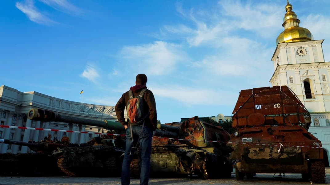Мужчина стоит перед экспозицией уничтоженных российских танков и бронетехники возле Михайловского Златоверхого монастыря в Киеве, 11 сентября 2022 года