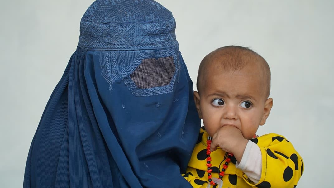 Женщина, одетая в бурку, с ребенком на руках, Кабул, Афганистан. Иллюстративное фото