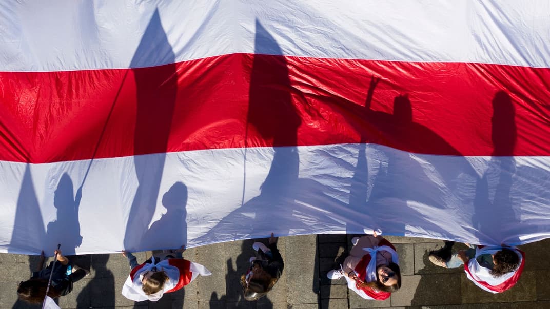 Білоруські активісти несуть старий білоруський прапор на мітингу на підтримку білоруської опозиції в Києві, Україна, 20 вересня 2020 року