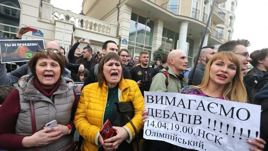 Участницы акции с плакатом «Требуем дебатов» у главного офиса кандидата в президенты Украины Владимира Зеленского в Киеве, 9 апреля 2019 г.