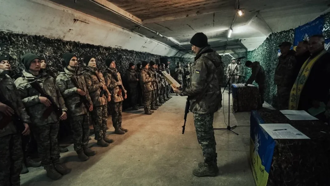 Ілюстративне фото. Молодий доброволець читає текст присяги перед побратимами