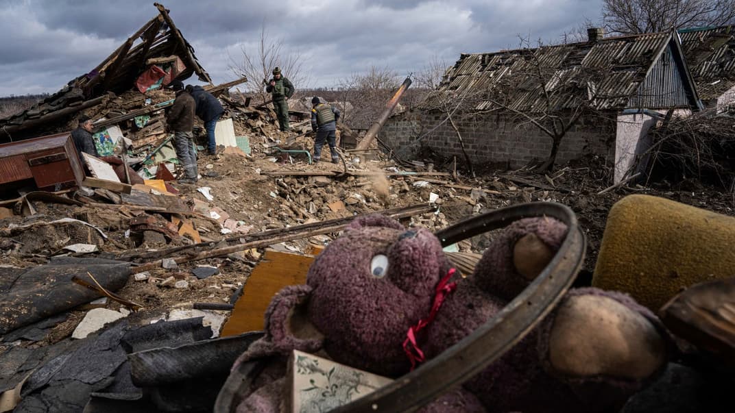 Господарі та їхні сусіди розчищають завали будинку, зруйнованого російською ракетою в селі Максимільянівка на Донеччині, 21 лютого 2023 року