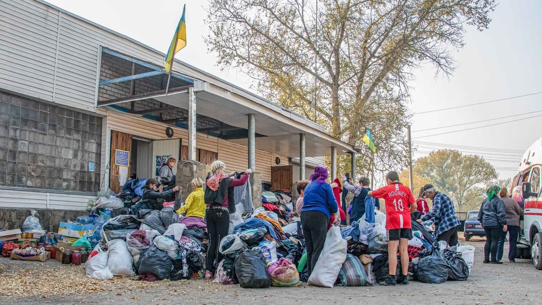 Жители села Муратово в Луганской области разбирают одежду, привезенную им в качестве материальной помощи