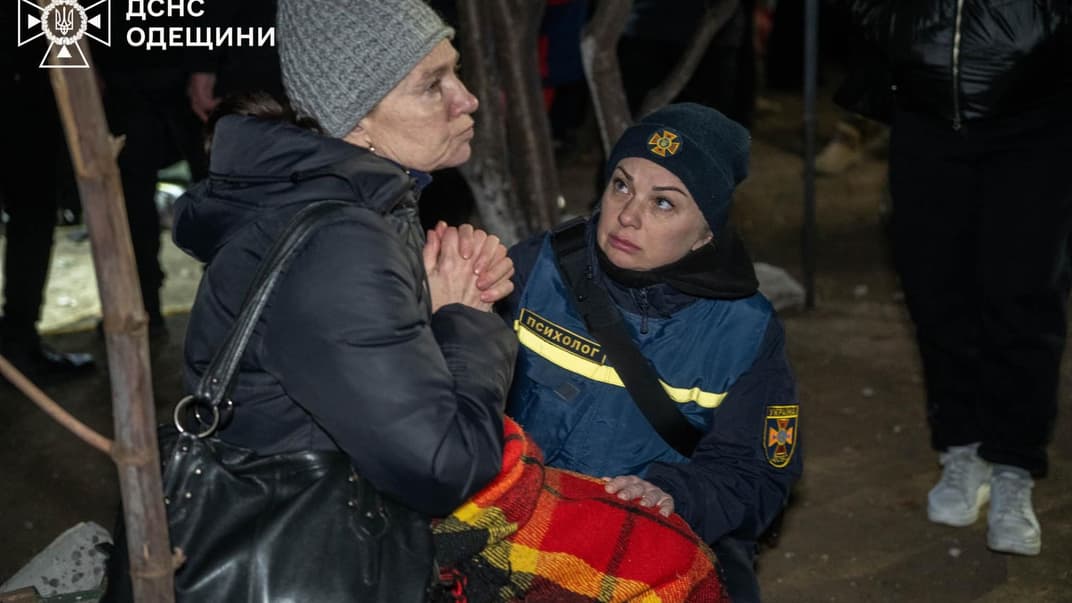 Психолог успокаивает женщину в Одессе после российской атаки дроном по многоэтажке, 2 марта 2024 года