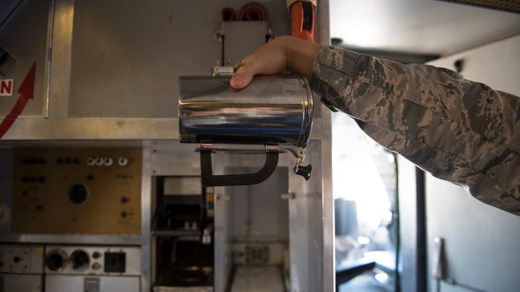 Військовий тримає кухоль на борту заправника  KC-10 Extender