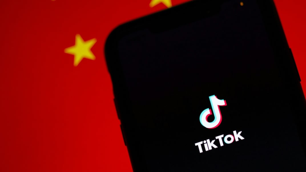 Ілюстративне фото. Застосунок TikTok, запущений на смартфоні, на тлі китайського прапора