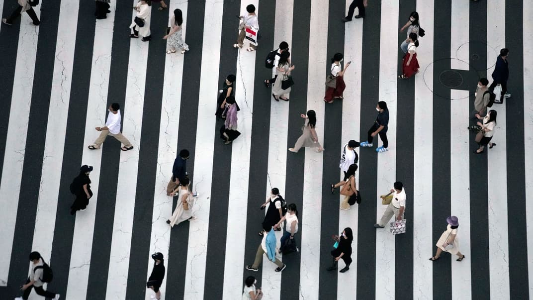 Люди в захисних масках проти коронавірусу йдуть по пішохідному переходу у Токіо, Японія, 22 липня 2021 року.
