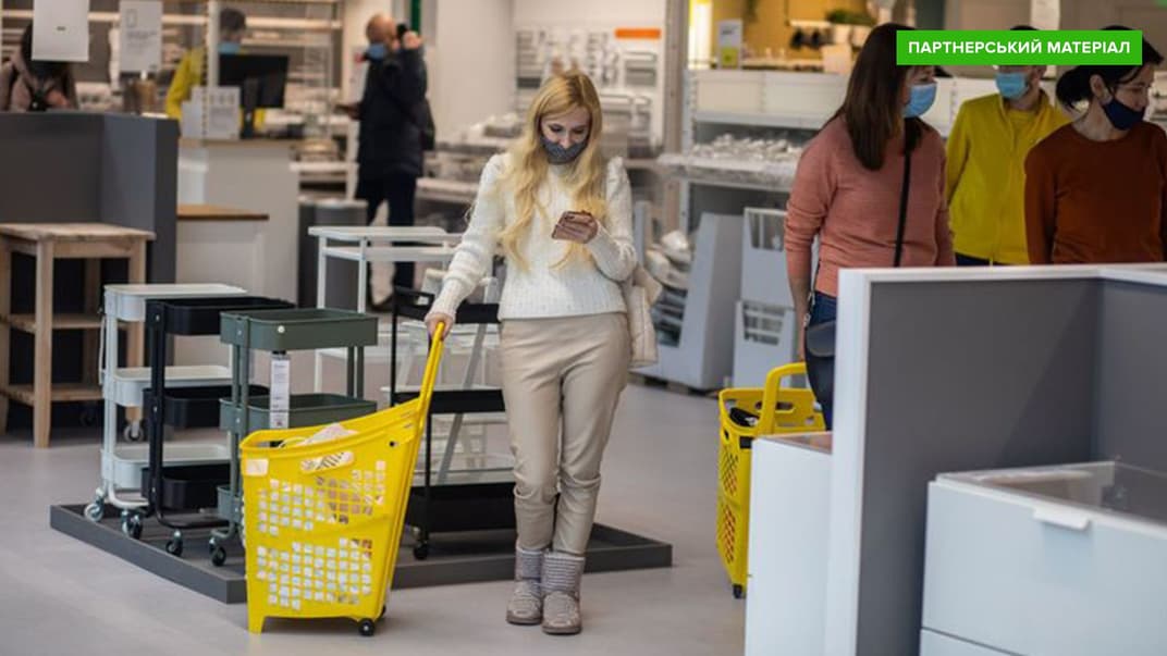 Жінка дивиться у смартфон під час шопінгу у магазині меблів у Києві.