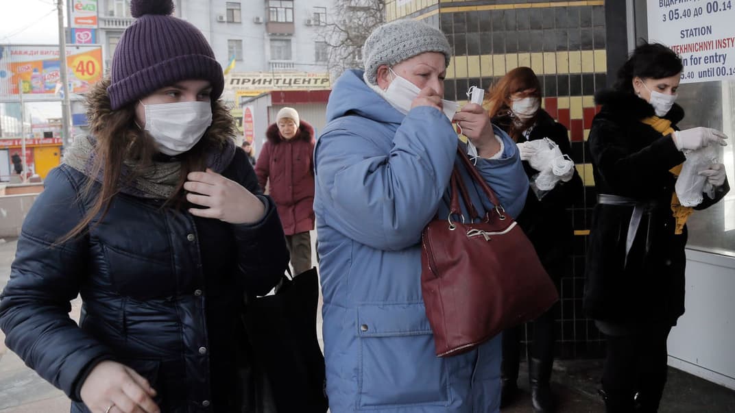 Люди в масках для обличчя заходять до метро «Політехнічний інститут» у Києві