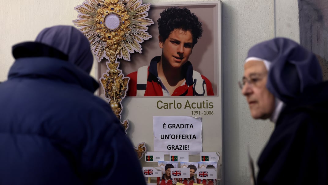 Монахині моляться біля могили Карла Акутіса в церкві в Ассізі, Італія