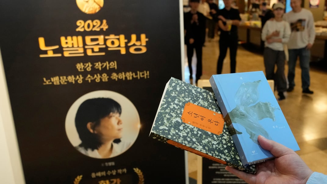 Відвідувачка робить пам’ятне фото після купівлі книжок південнокорейської письменниці Хан Канг біля спеціального відділу у книжковому магазині в Сеулі, Південна Корея, 11 жовтня 2024 року