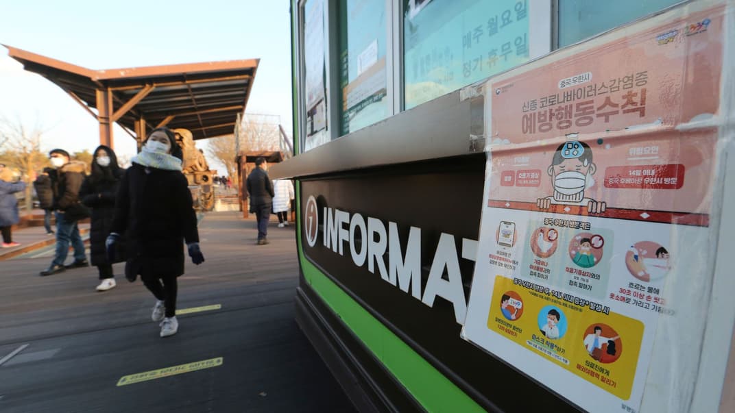 Жителі Північної Кореї проходять повз інформаційний стенд про коронавірус. Пхеньян, 1 січня 2021 року