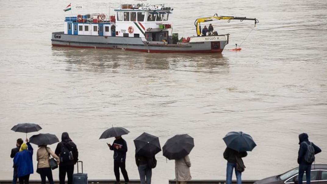 Люди наблюдают с моста Маргит за ходом поисковой операции на реке Дунай в Будапеште, Венгрия, 30 мая 2019 года. Накануне там затонул прогулочный катер с 35 пассажирами