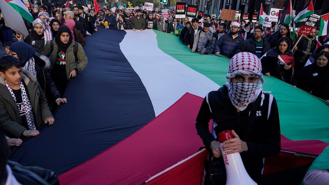 Протестующие держат гигантский палестинский флаг во время пропалестинского протеста в Лондоне, 11 ноября 2023 года