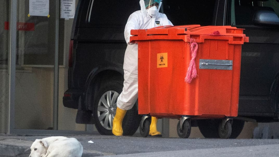 Медицинский работник вывозит контейнер для мусора с медицинскими отходами в больнице в Стамбуле, Турция, 3 апреля 2020