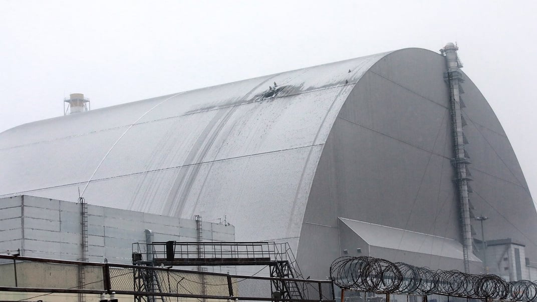 Українські рятувальники працюють на місці влучання російського безпілотника в Новий безпечний конфайнмент на Чорнобильській АЕС