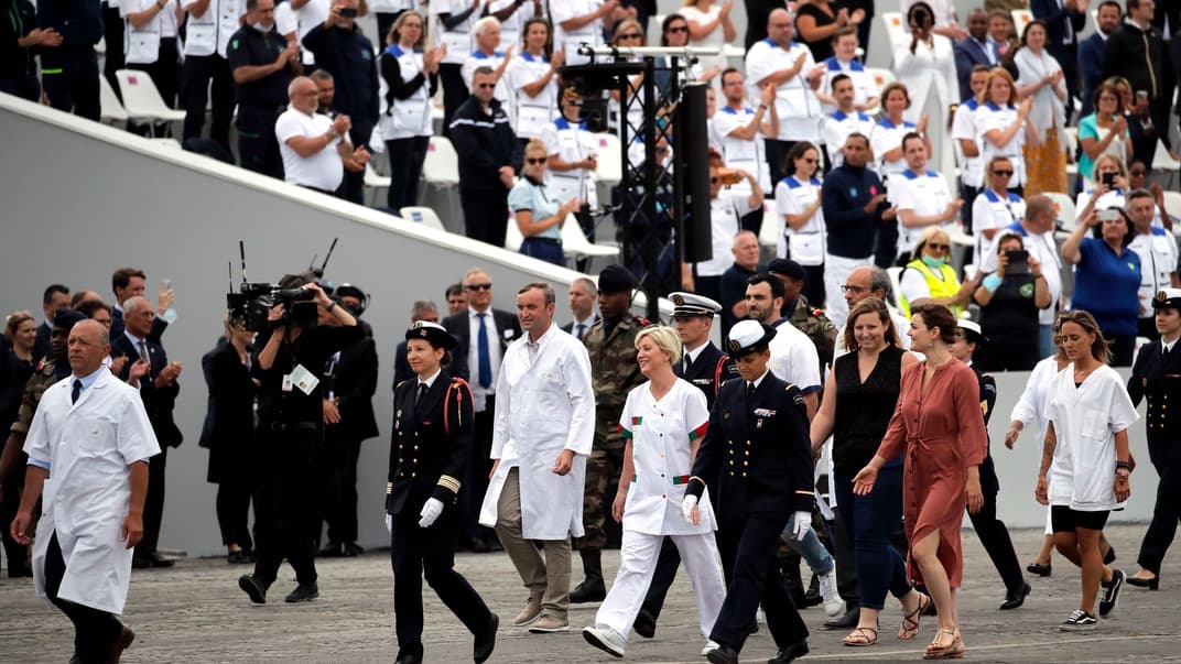 Люди аплодируют работникам сферы здравоохранения Франции во время церемонии ко Дню взятия Бастилии, Париж, Франция, 14 июля 2020 года