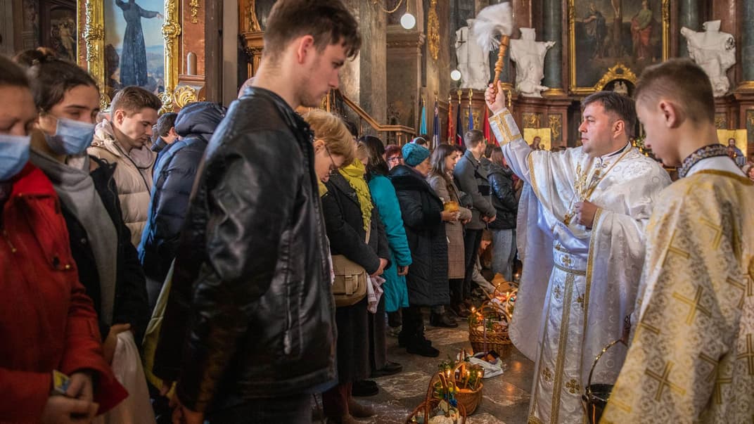 Священник освячує великодні кошики із їжею у гарнізонному храмі святого Петра і Павла у Львові, 24 квітня 2022 року