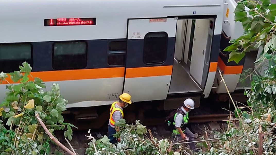 Рятувальники йдуть біля ділянки поїзда, що зійшов з рейок поблизу району ущелини, Тайвань, п'ятниця, 2 квітня 2021 року
