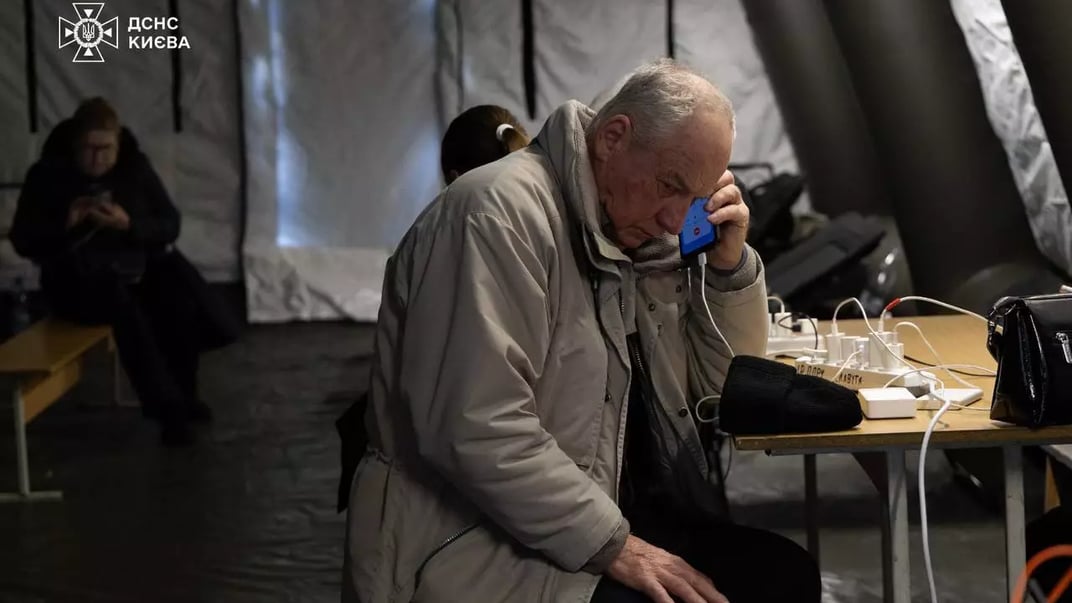 Чоловік заряджає телефон в пункті незламності