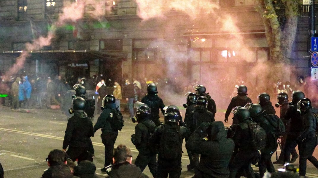 Грузинська поліція проходить повз протестувальників під час заворушень у Тбілісі, 30 листопада