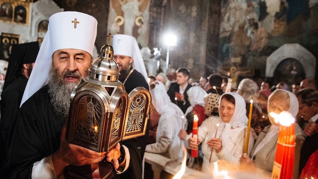 Глава Української православної церкви Московського патріархату (УПЦ МП) митрополит Онуфрій (ліворуч) передає «святий вогонь» під час Великодньої служби в церкві Києво-Печерської Лаври, Київ, 30 квітня 2016 року