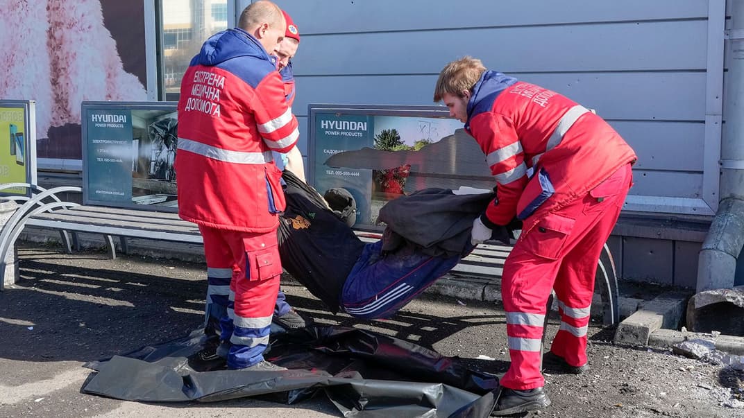 Харківські працівники швидкої допомоги забирають загиблого