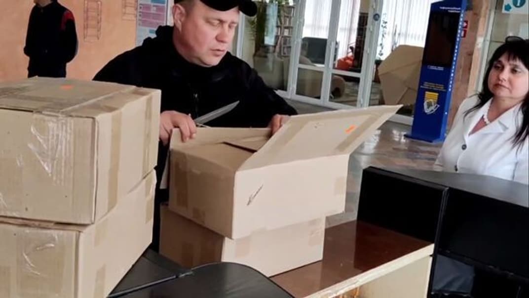Депутат російської держдуми Ігор Костюкевич у херсонській бібліотеці відкриває коробки з книжками «від путіна»
