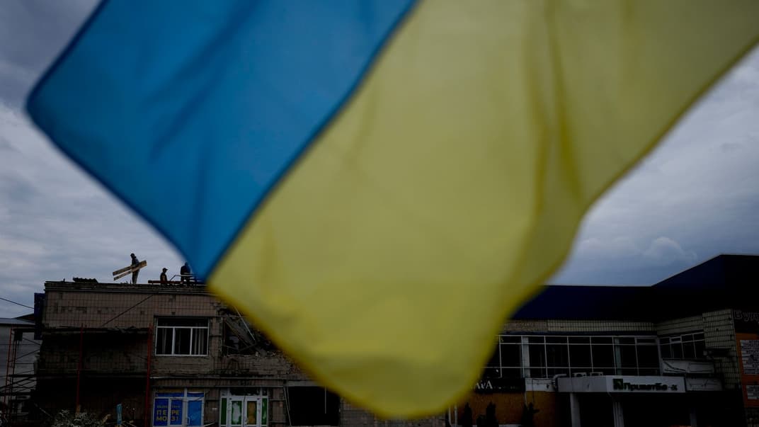 Чоловіки ремонтують будівлю у Макарові (Київська область), пошкоджену унаслідок обстрілу, 27 травня 2022 року