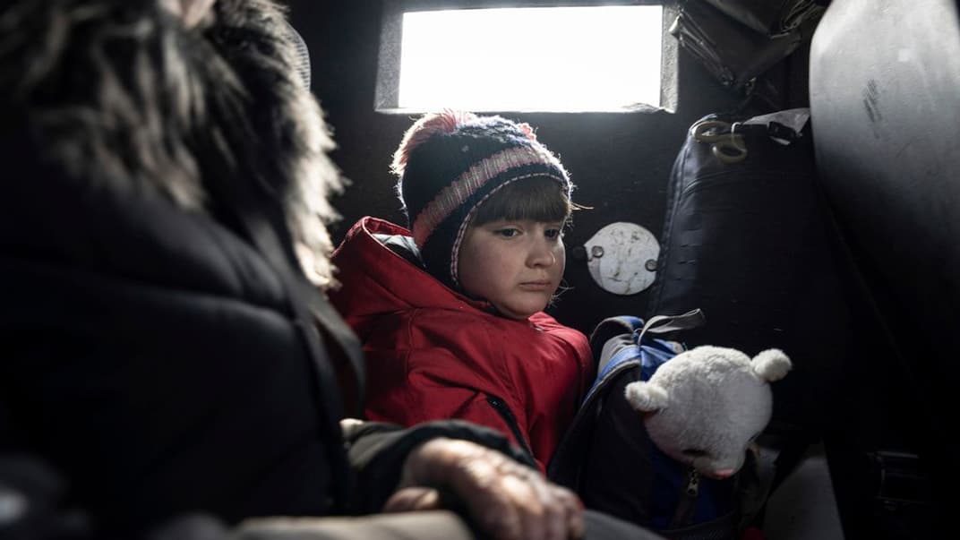 Девочка с матерью едет в микроавтобусе во время эвакуации из Авдеевки, которую проводит украинская полиция, 7 марта 2023 года