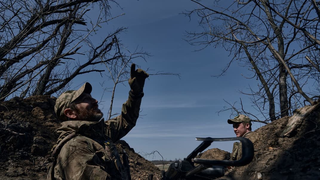 Український військовий показує на російський безпілотник з траншеї на передовій у Бахмуті Донецької області, 10 квітня 2023 року