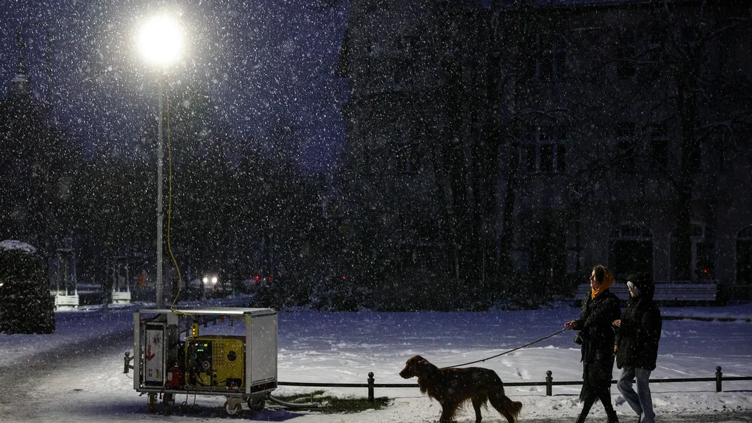 Жінка з дитиною вигулюють свого собаку під час відключення електроенергії після підпалу кабелів, Берлін, Німеччина, 4 січня 2026 року