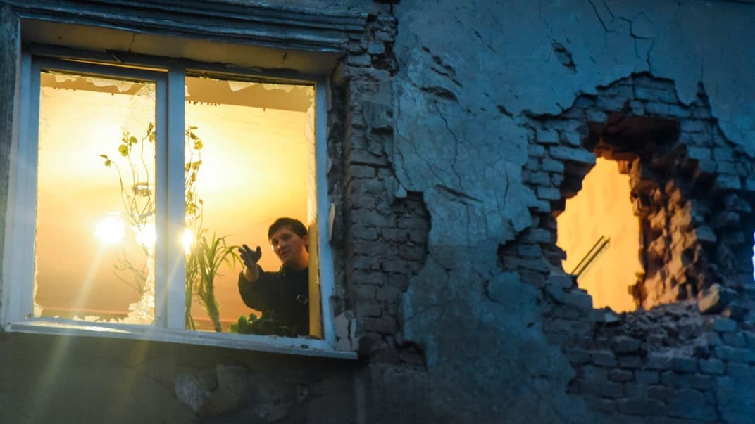 Люди осматривают повреждения в своей квартире после обстрела между поддерживаемыми Россией сепаратистами и украинскими правительственными войсками, Донецк, Украина