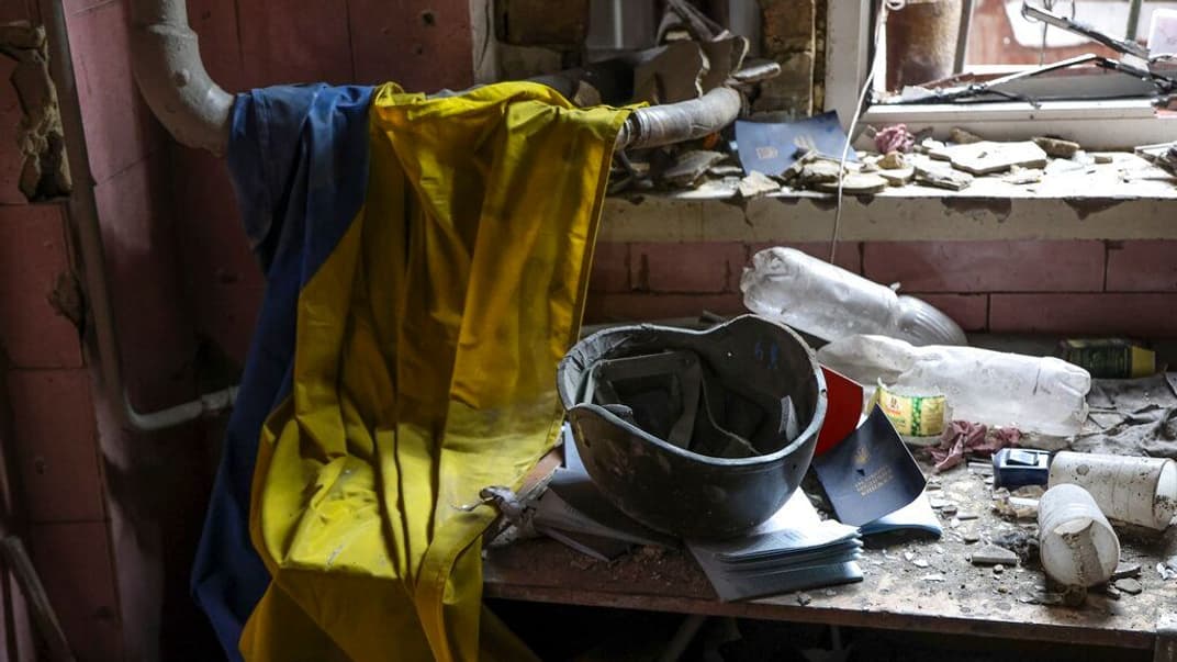 Український прапор, шолом та документи медика у зруйнованому приміщенні в Маріуполі, 18 квітня 2022 року