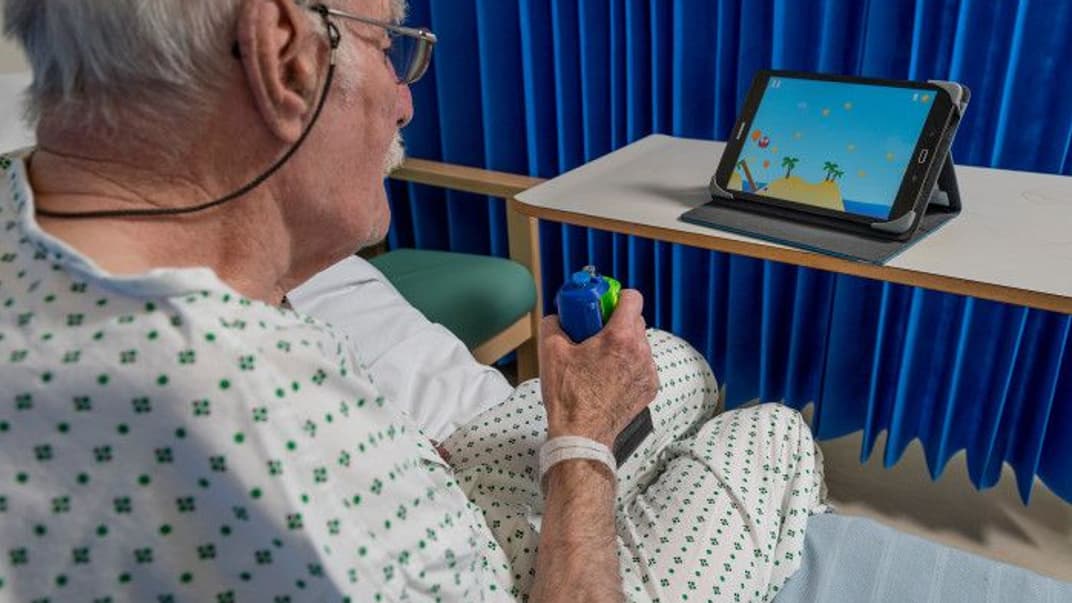 Мужчина с джойстиком, который помогает в реабилитации после инсульта