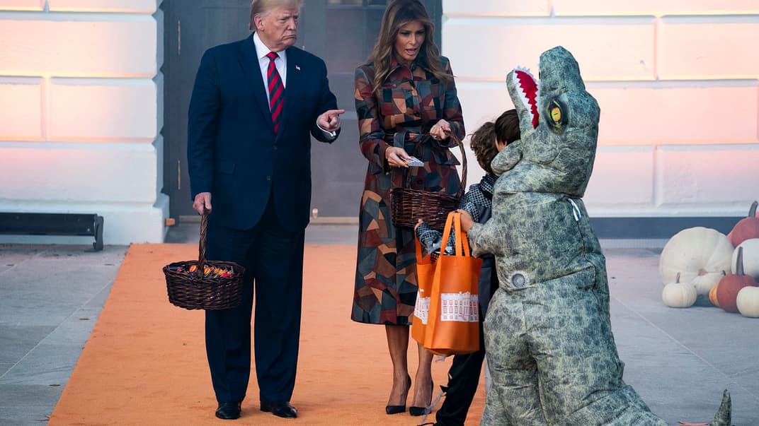 Президент США Дональд Трамп и первая леди Мелания Трамп раздают конфеты детям в костюмах во время празднования Хеллоуина в Белом доме в Вашингтоне, США, 28 октября 2019 года