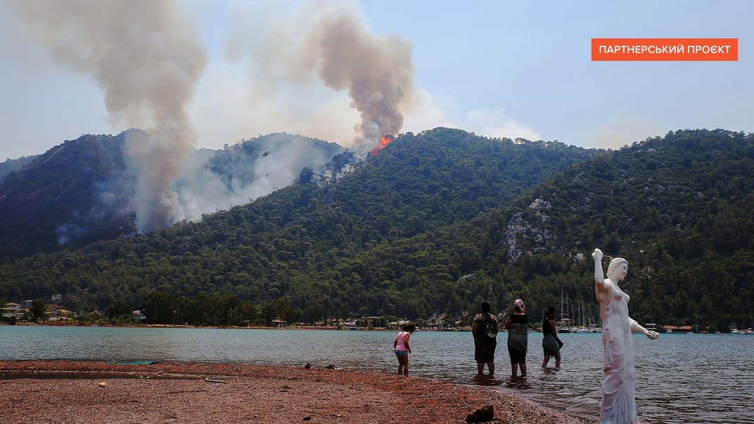 Люди наблюдают за пожаром в лесу вблизи туристического курорта Мармарис, Стамбул, Турция, 4 августа 2021 года