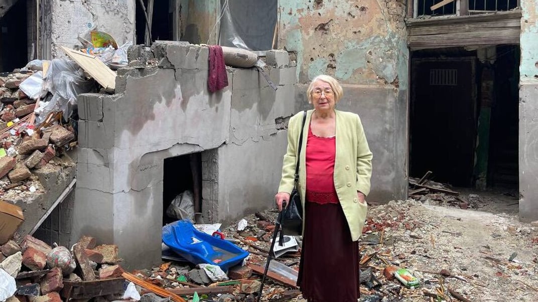 Христина Гоянюк біля зруйнованого російським обстрілом будинку